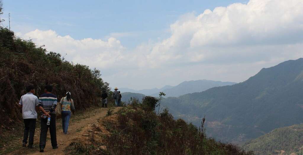 Master Zhou and his student Mr. Deng walk down a road built by Mr. Deng himself to allow his truck to carry fresh picked tea back to his workshop faster.