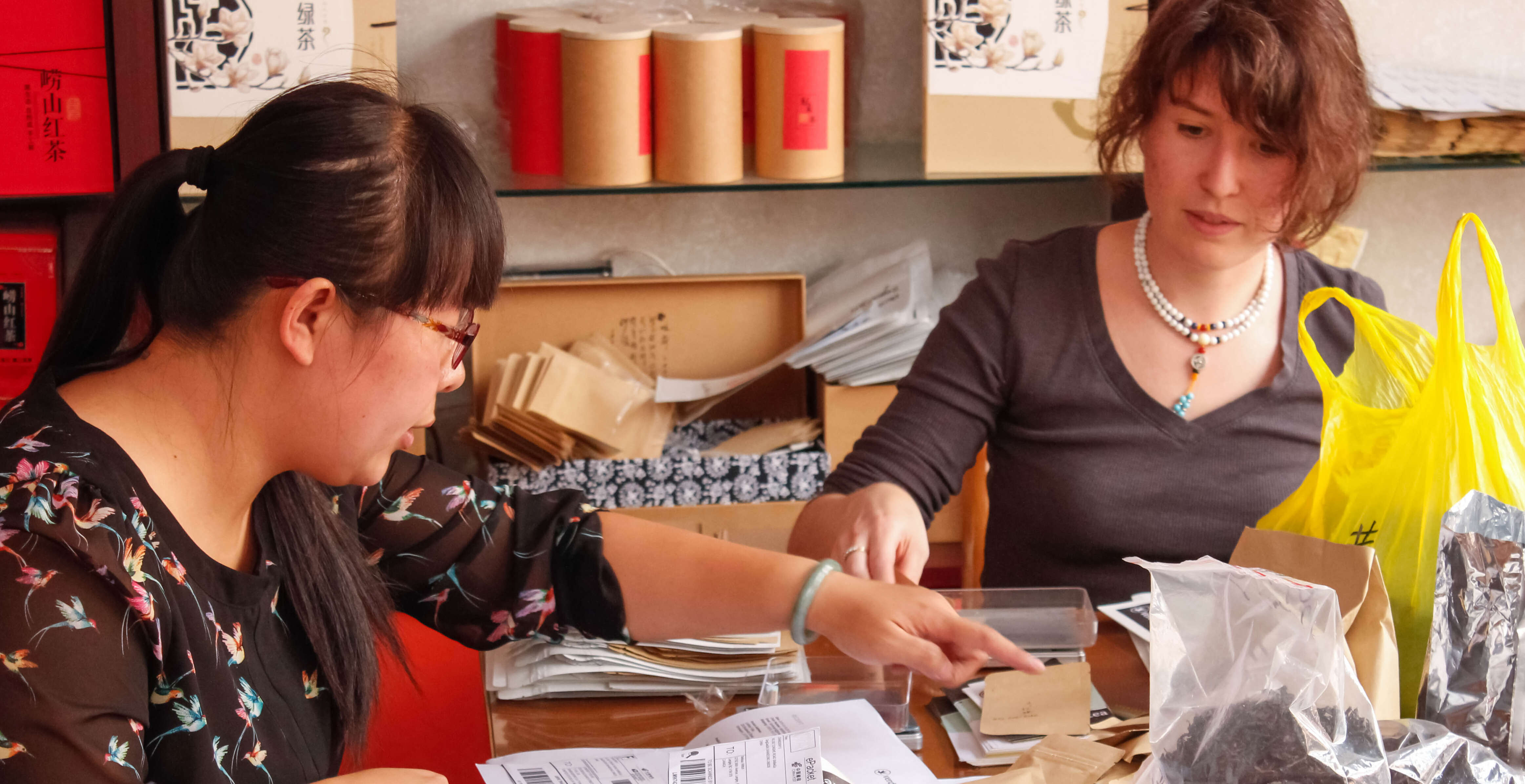 He Qingqing and Lily Duckler brainstorm packaging solutions together in Laoshan